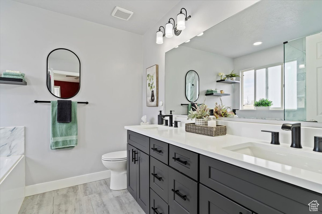 Full bath with a sink, visible vents, toilet, and baseboards