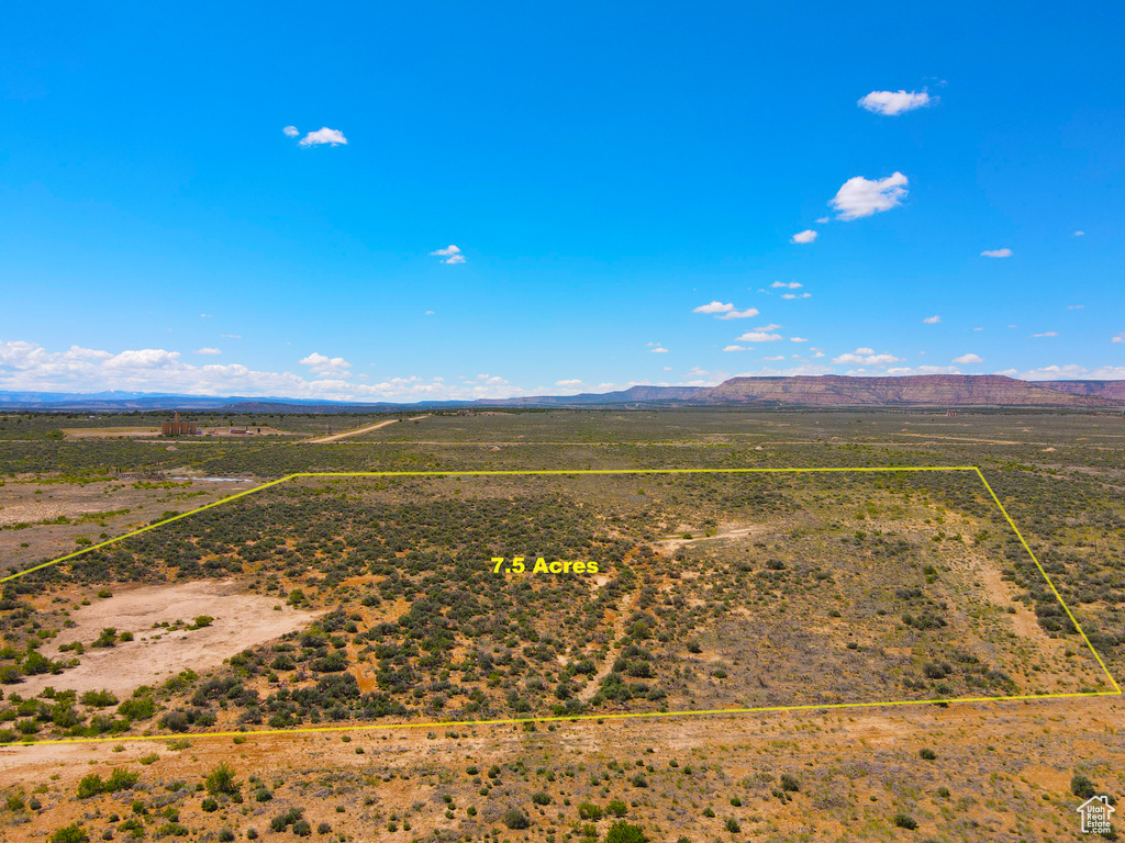 Aerial view of sparsely populated area with property boundaries highlighted and a mountainous background