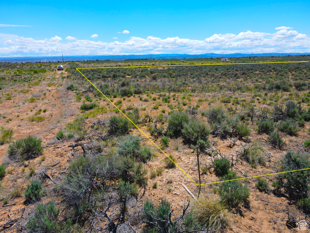 Aerial view of sparsely populated area with property parcel outlined and a mountainous background