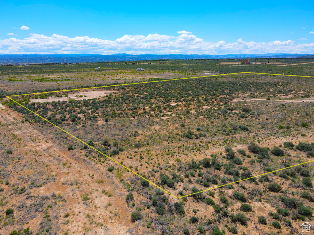 Aerial view of sparsely populated area with property parcel outlined and a mountainous background