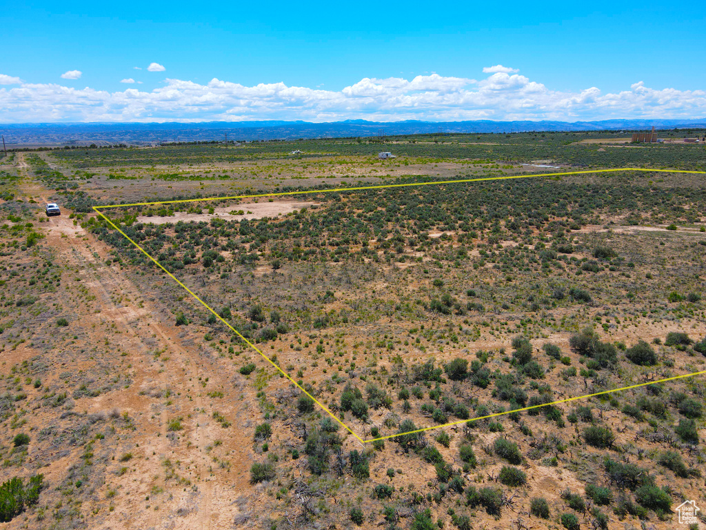 Aerial view of sparsely populated area featuring property parcel outlined and a mountain backdrop