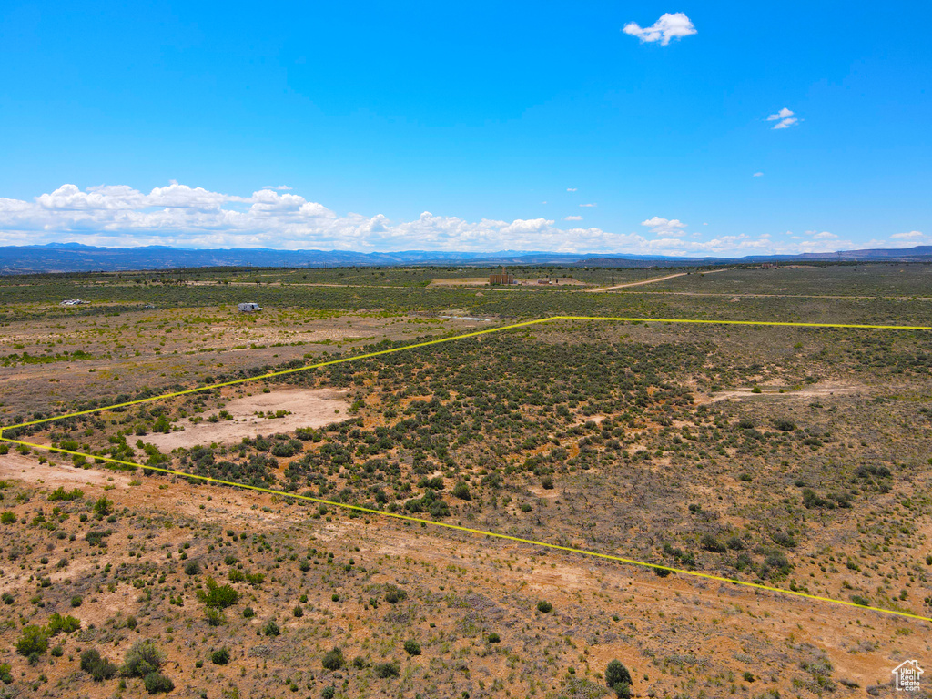Aerial view of sparsely populated area with property parcel outlined, a mountainous background, and a desert landscape