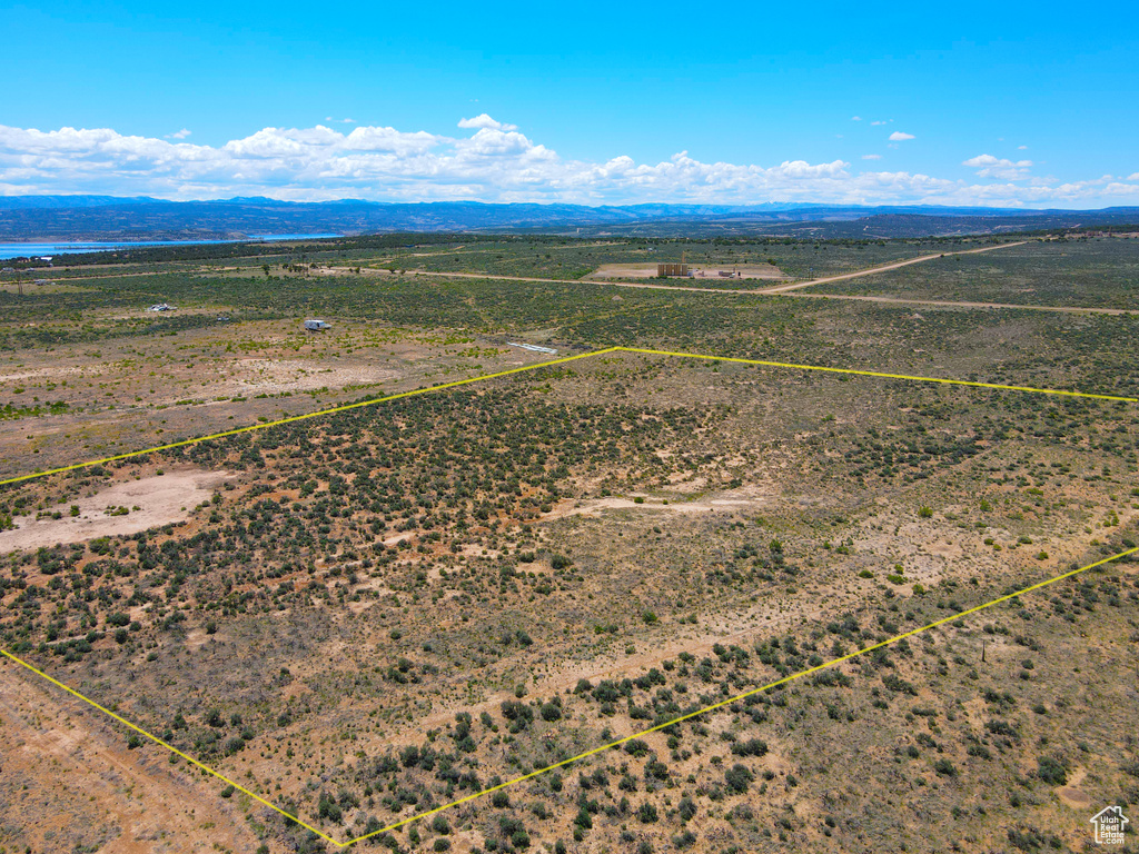 Aerial view of sparsely populated area featuring property parcel outlined and a mountain backdrop