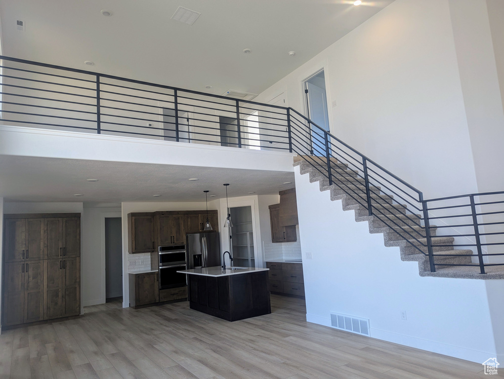 Stairs featuring a high ceiling and wood finished floors
