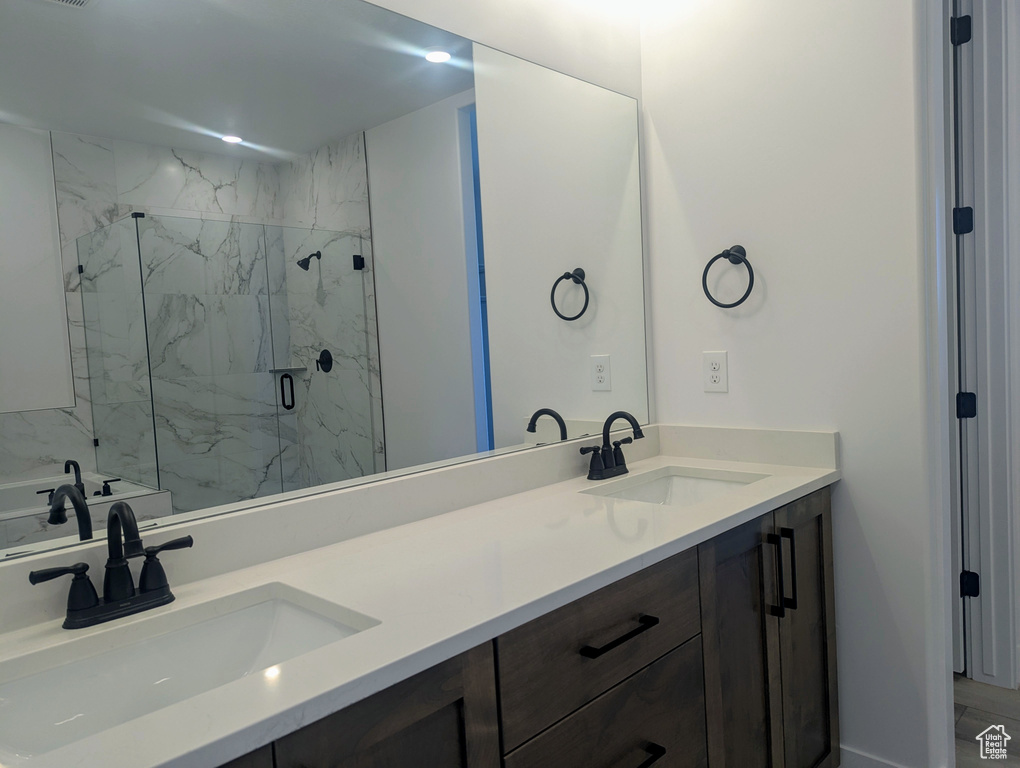 Bathroom with double vanity and a marble finish shower