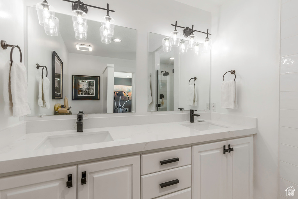 Full bathroom featuring double vanity and a shower