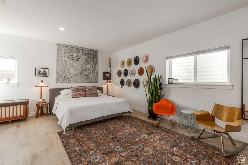 Bedroom featuring wood finished floors, multiple windows, recessed lighting, and baseboards