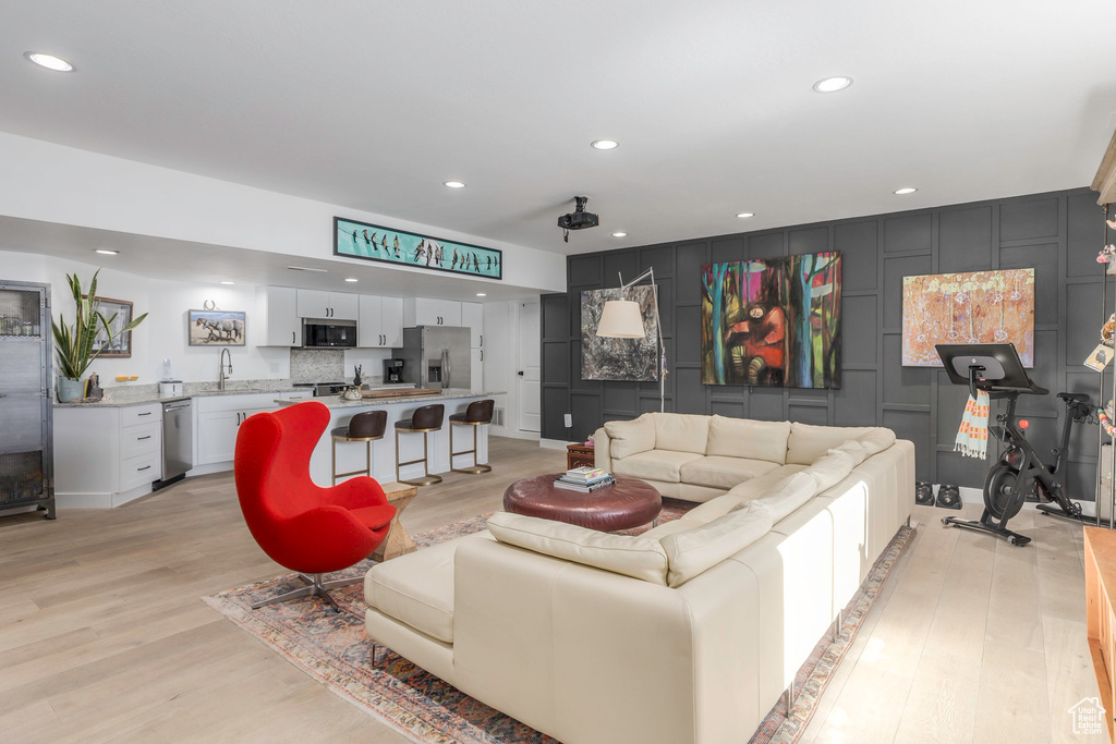 Living room with light wood finished floors and recessed lighting