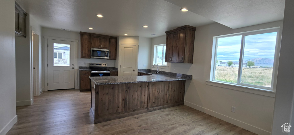 Kitchen with appliances with stainless steel finishes, healthy amount of natural light, baseboards, a sink, and recessed lighting