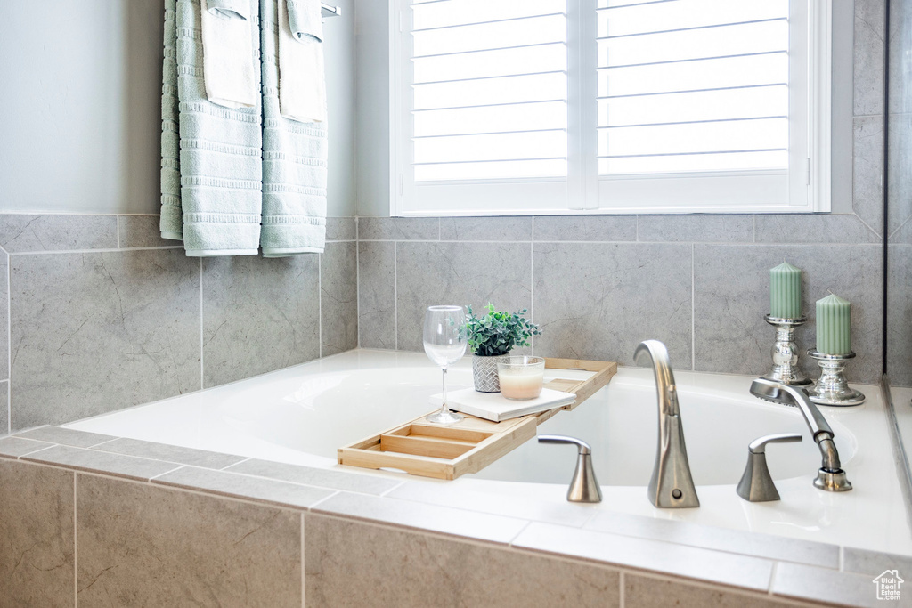 Full bathroom with a garden tub and a healthy amount of sunlight