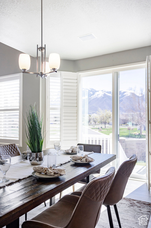 Dining room with an inviting chandelier and a wealth of natural light