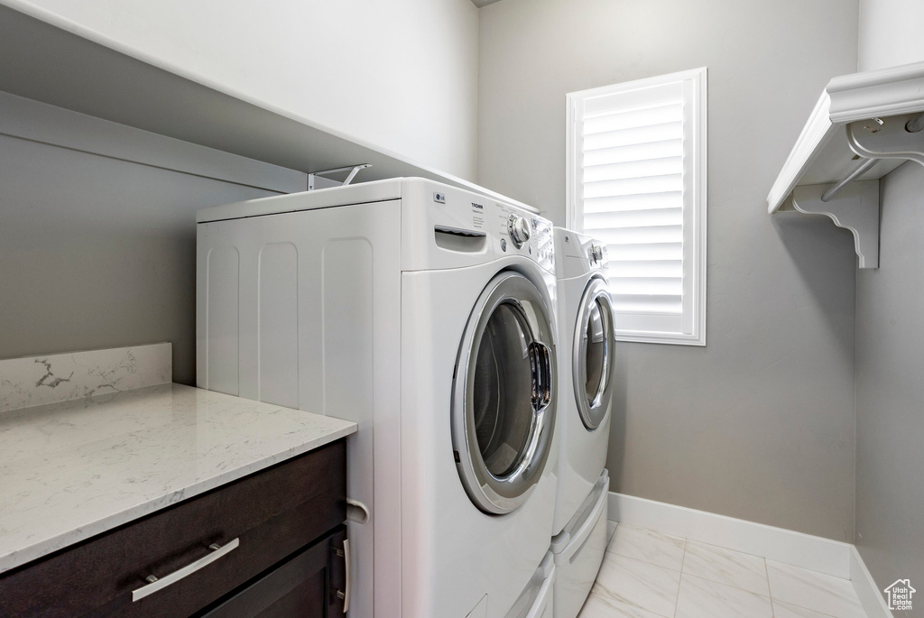 Clothes washing area with independent washer and dryer, marble finish floor, laundry area, and baseboards
