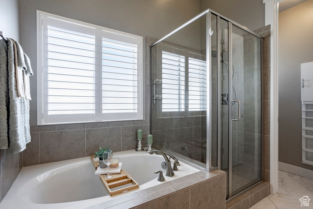 Bathroom with a shower stall, a bath, and marble finish floor