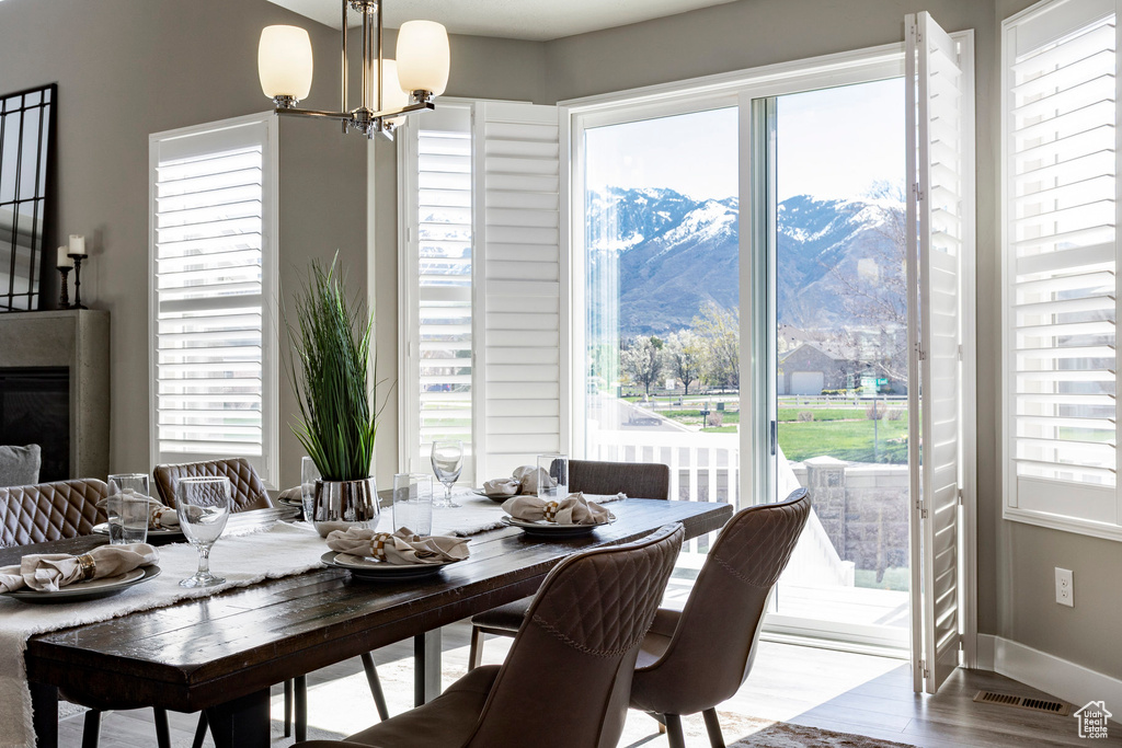 Dining room featuring a mountain view, visible vents, baseboards, a chandelier, and wood finished floors