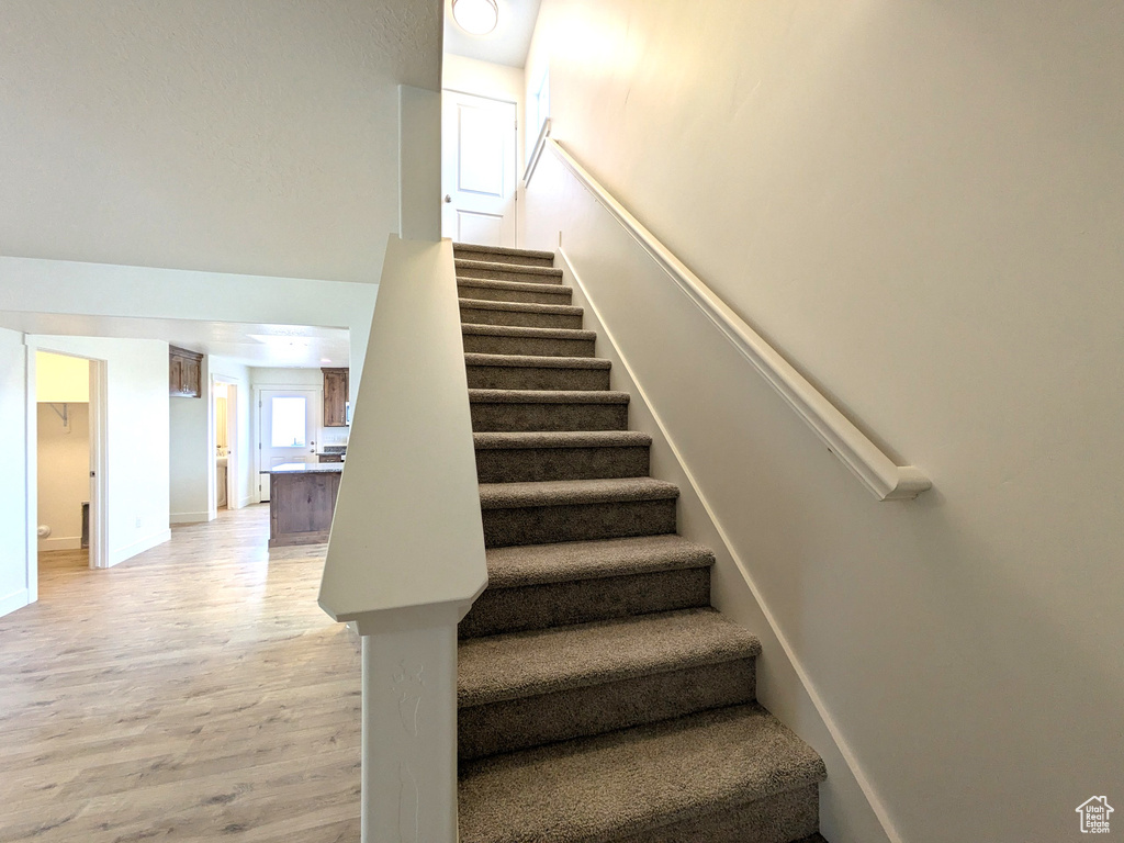 Stairs with baseboards and wood finished floors