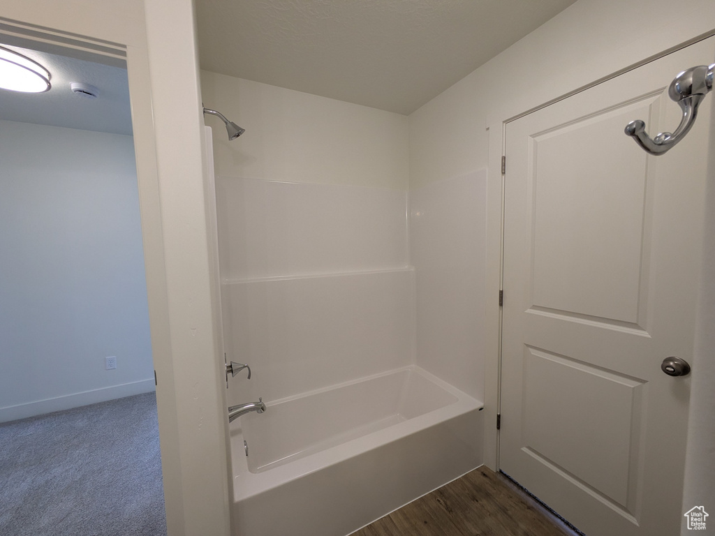 Bathroom with baseboards and shower / washtub combination