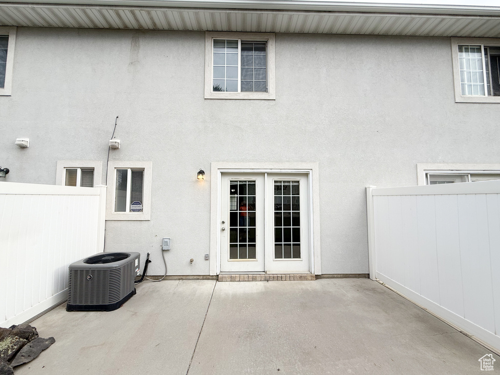 Back of property with a patio area, fence, stucco siding, and central air condition unit