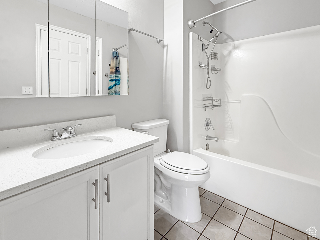 Full bath with shower / bathtub combination, toilet, tile patterned flooring, and vanity