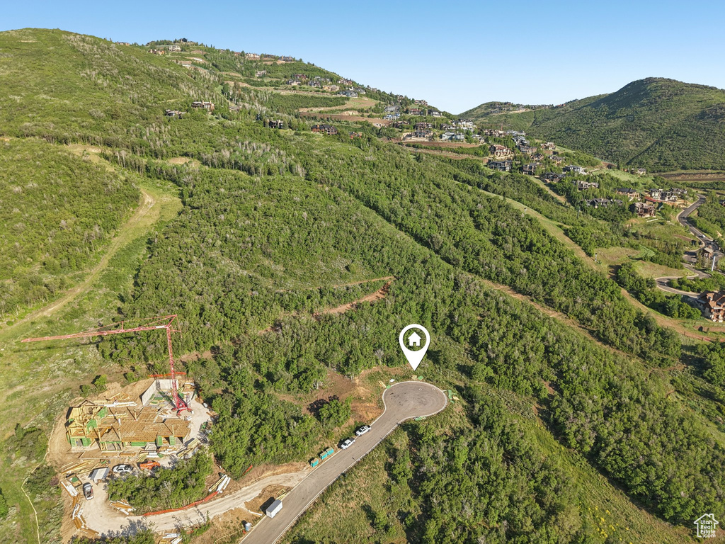 Aerial view of property's location with a mountainous background and a forest