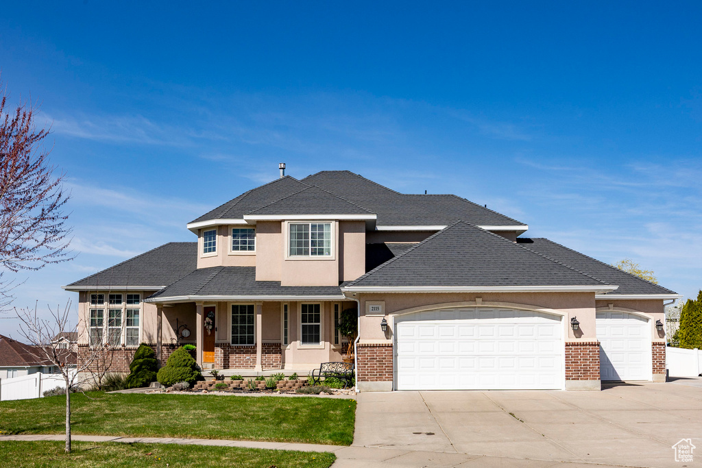 View of front facade featuring a garage, stucco siding, and concrete driveway