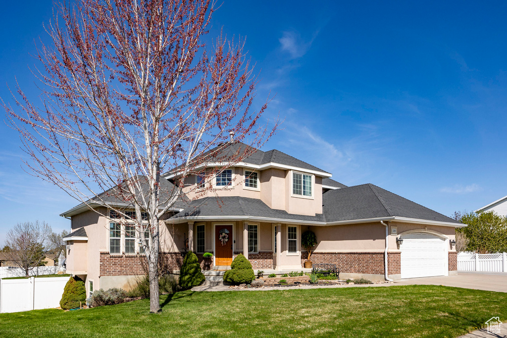 View of front of house with brick siding, stucco siding, concrete driveway, and a garage