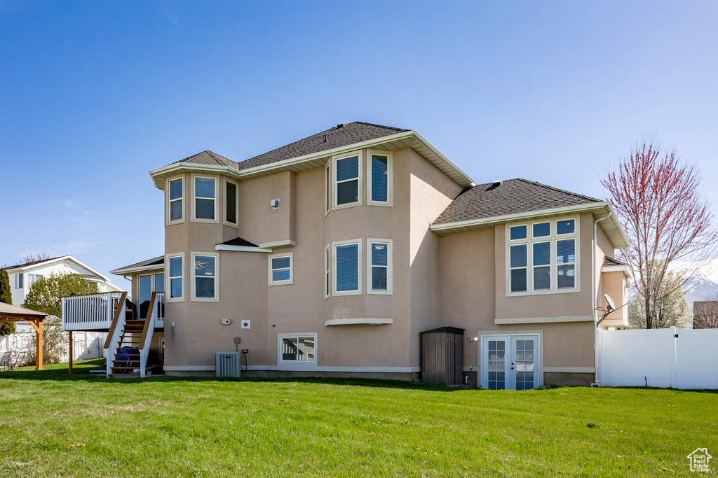 Back of house featuring stucco siding, french doors, stairs, and a deck