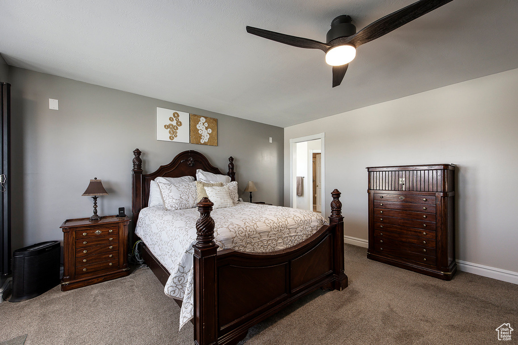 Carpeted bedroom with a ceiling fan and connected bathroom