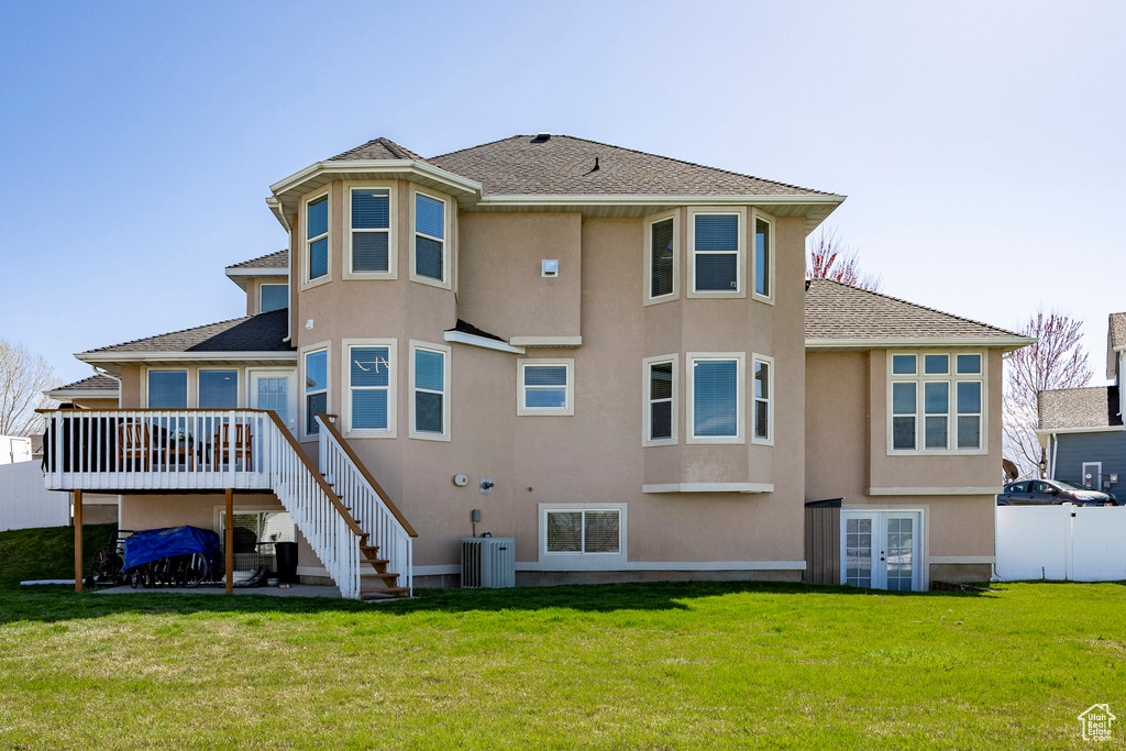 Back of house featuring stairway, a deck, stucco siding, and french doors