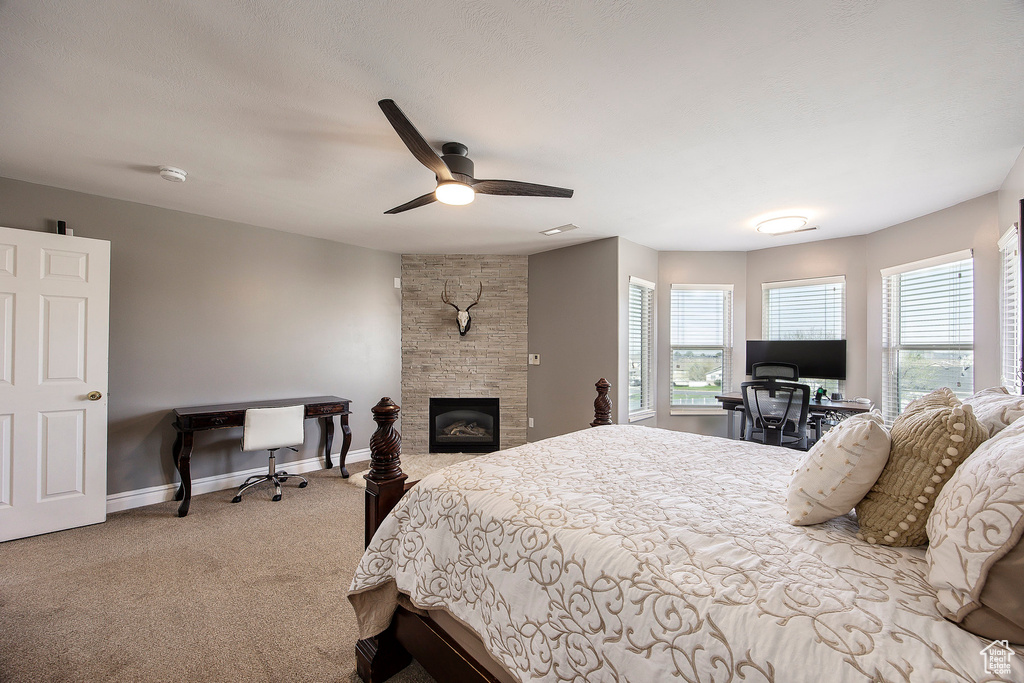 Bedroom featuring a desk, carpet floors, a fireplace, and a ceiling fan