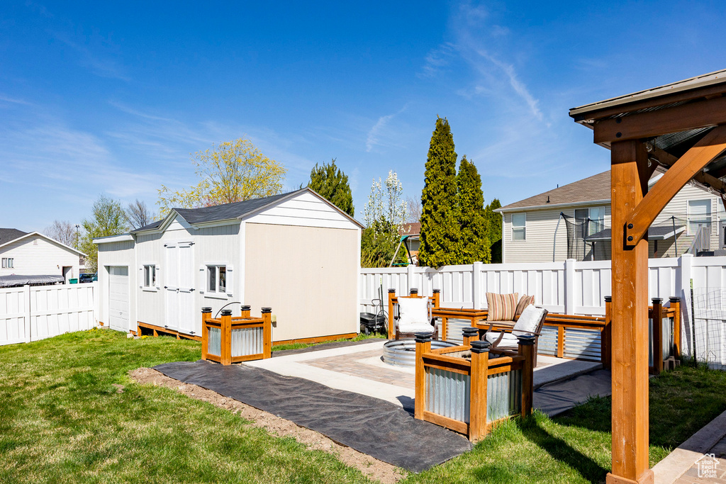 Fenced backyard featuring a shed, a patio, and a residential view