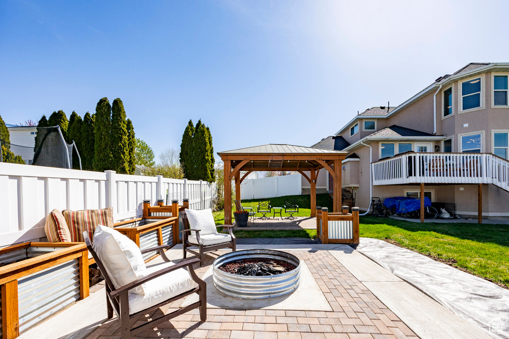 Fenced backyard with a patio area, a gazebo, and an outdoor living space with a fire pit