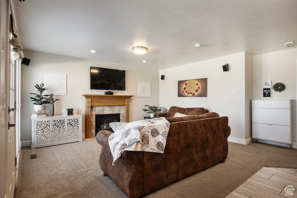 Living area featuring carpet flooring, a tile fireplace, and recessed lighting