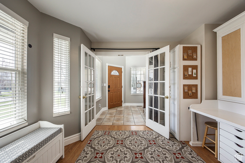 Entryway featuring french doors, light wood-style floors, healthy amount of natural light, and radiator