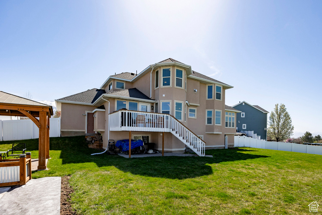 Back of property featuring stairway, stucco siding, a deck, and a gazebo