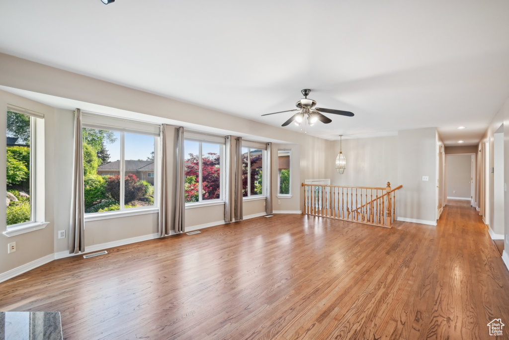 Unfurnished room with a ceiling fan, light wood-style floors, and baseboards