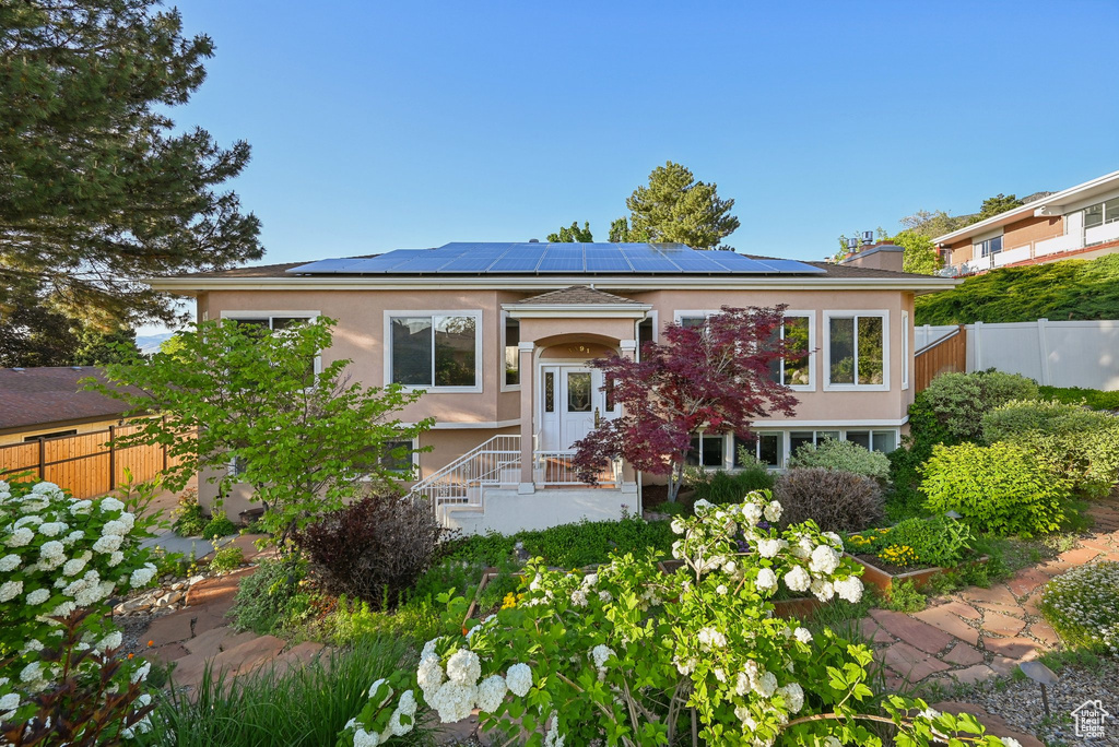 View of front of house with solar panels and stucco siding