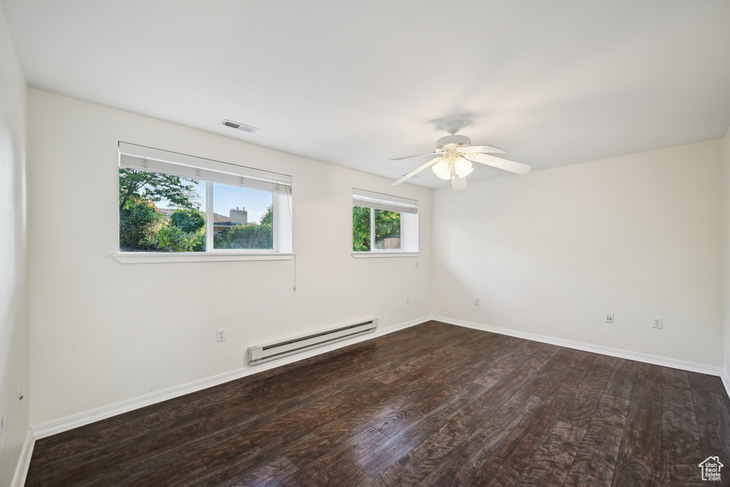 Unfurnished room with a baseboard heating unit, wood finished floors, a ceiling fan, and baseboards