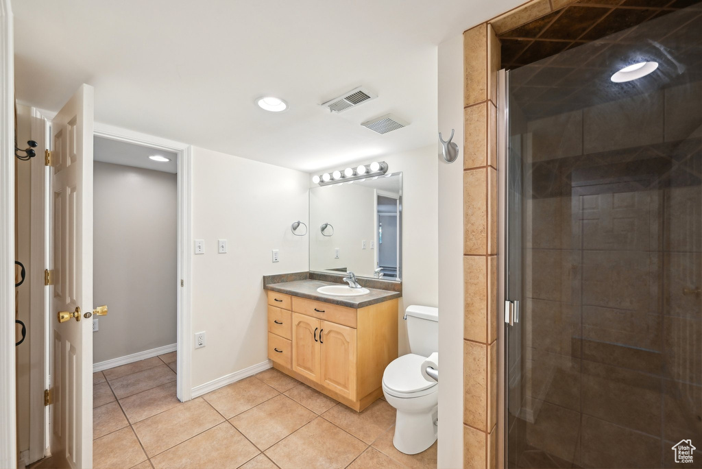 Bathroom with toilet, tile patterned flooring, vanity, a stall shower, and baseboards