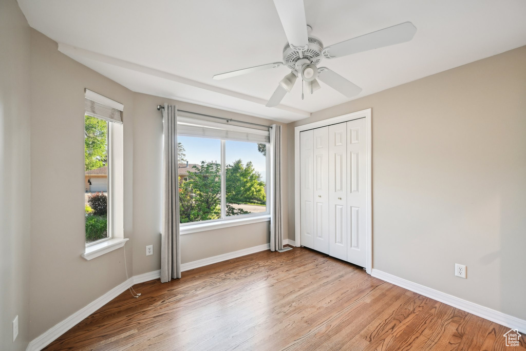 Unfurnished bedroom featuring baseboards, light wood-style floors, a closet, and ceiling fan