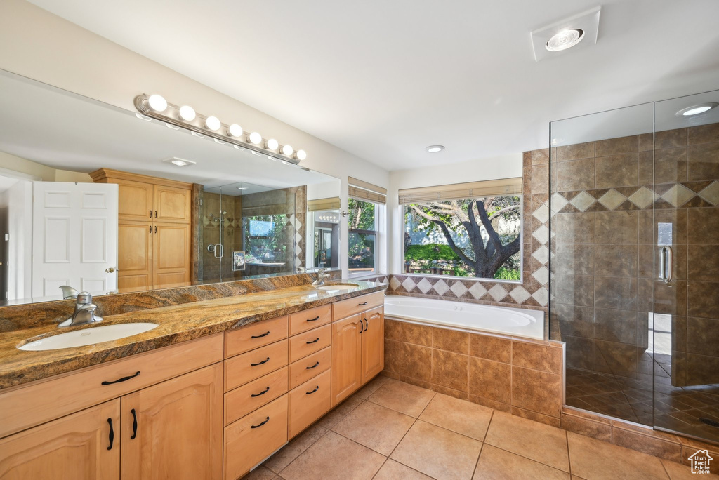 Bathroom featuring double vanity, tile patterned floors, a shower stall, and a garden tub