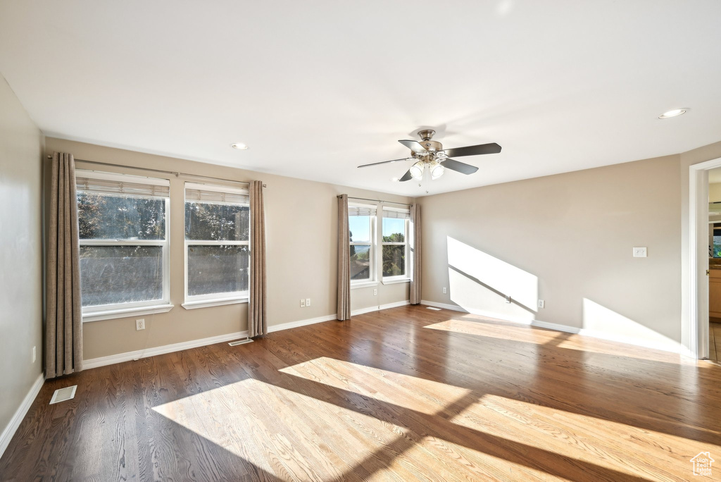 Unfurnished living room featuring wood finished floors, a ceiling fan, baseboards, and recessed lighting