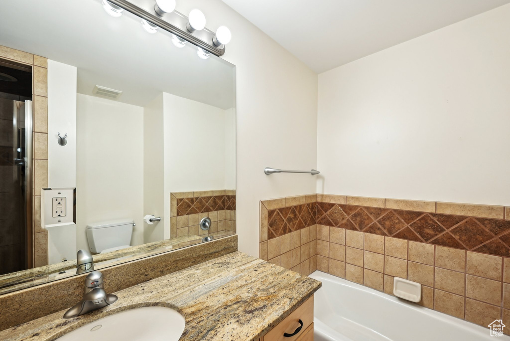 Full bath with a bath, vanity, and toilet
