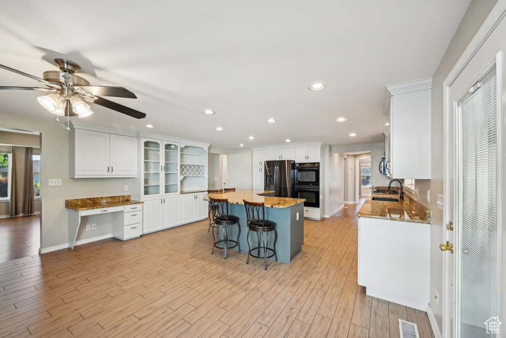 Kitchen with a sink, white cabinets, a kitchen island, ceiling fan, and recessed lighting