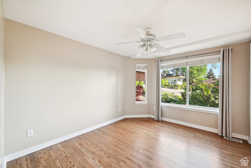 Unfurnished room featuring baseboards, wood finished floors, and a ceiling fan