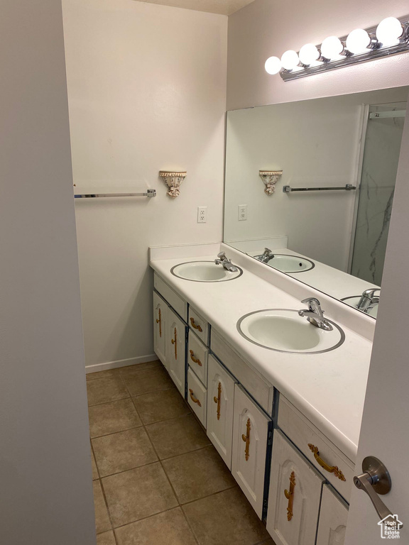 Bathroom with a sink, double vanity, and tile patterned flooring