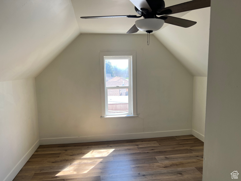 Additional living space with wood finished floors, baseboards, a ceiling fan, and lofted ceiling