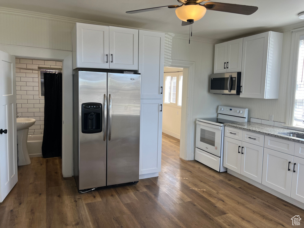 Kitchen with ceiling fan, white cabinetry, and stainless steel appliances