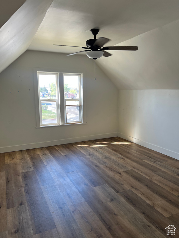 Additional living space featuring dark wood finished floors, baseboards, a ceiling fan, and lofted ceiling
