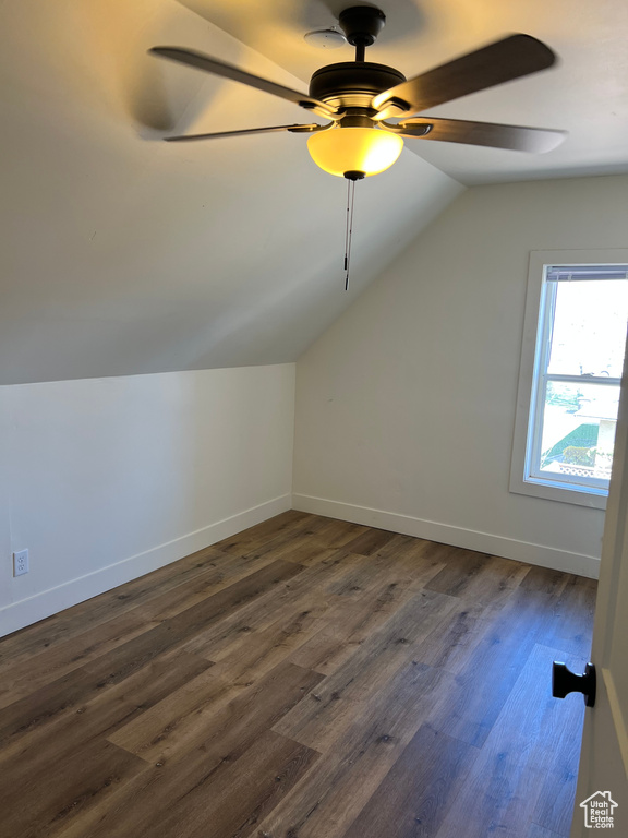 Additional living space with dark wood-style flooring, baseboards, a ceiling fan, and lofted ceiling