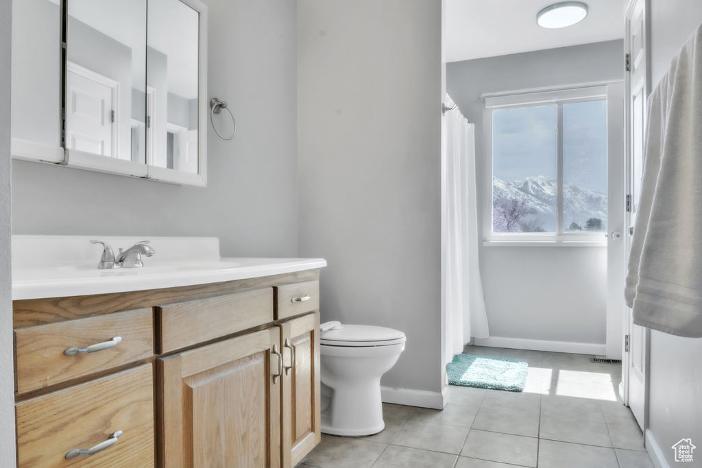 Full bathroom with baseboards, curtained shower, toilet, vanity, and tile patterned floors